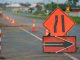Along a section of the road are the signals for construction. It has a sign that the lanes are narrowing and cones.