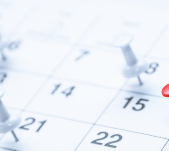 A red pushpin marks the 16th on a calendar while blurred white pins in the background highlight other scheduled dates.