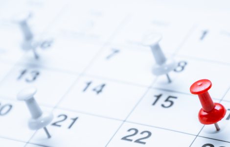 A red pushpin marks the 16th on a calendar while blurred white pins in the background highlight other scheduled dates.