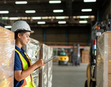 A group of individuals wearing suits reviews charts and solar panels on a table while one person holds a small globe.