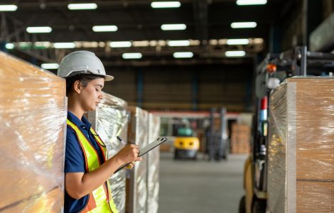 A group of individuals wearing suits reviews charts and solar panels on a table while one person holds a small globe.